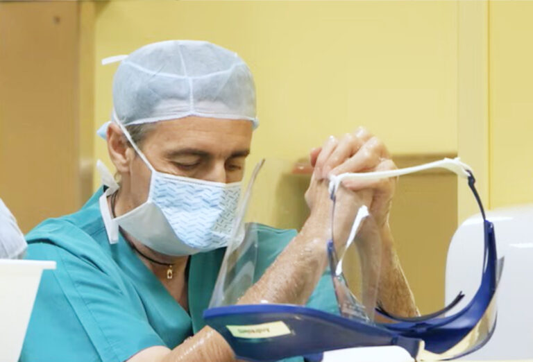 Medico con mascherina e cuffia prepara uno strumento diagnostico prima della visita