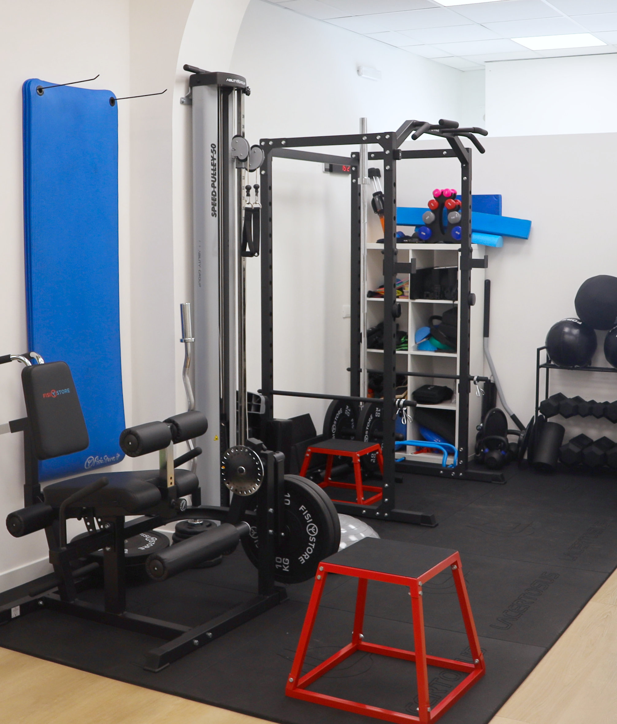 Angolo della palestra con power rack, box jump rossi e attrezzatura per esercizio funzionale